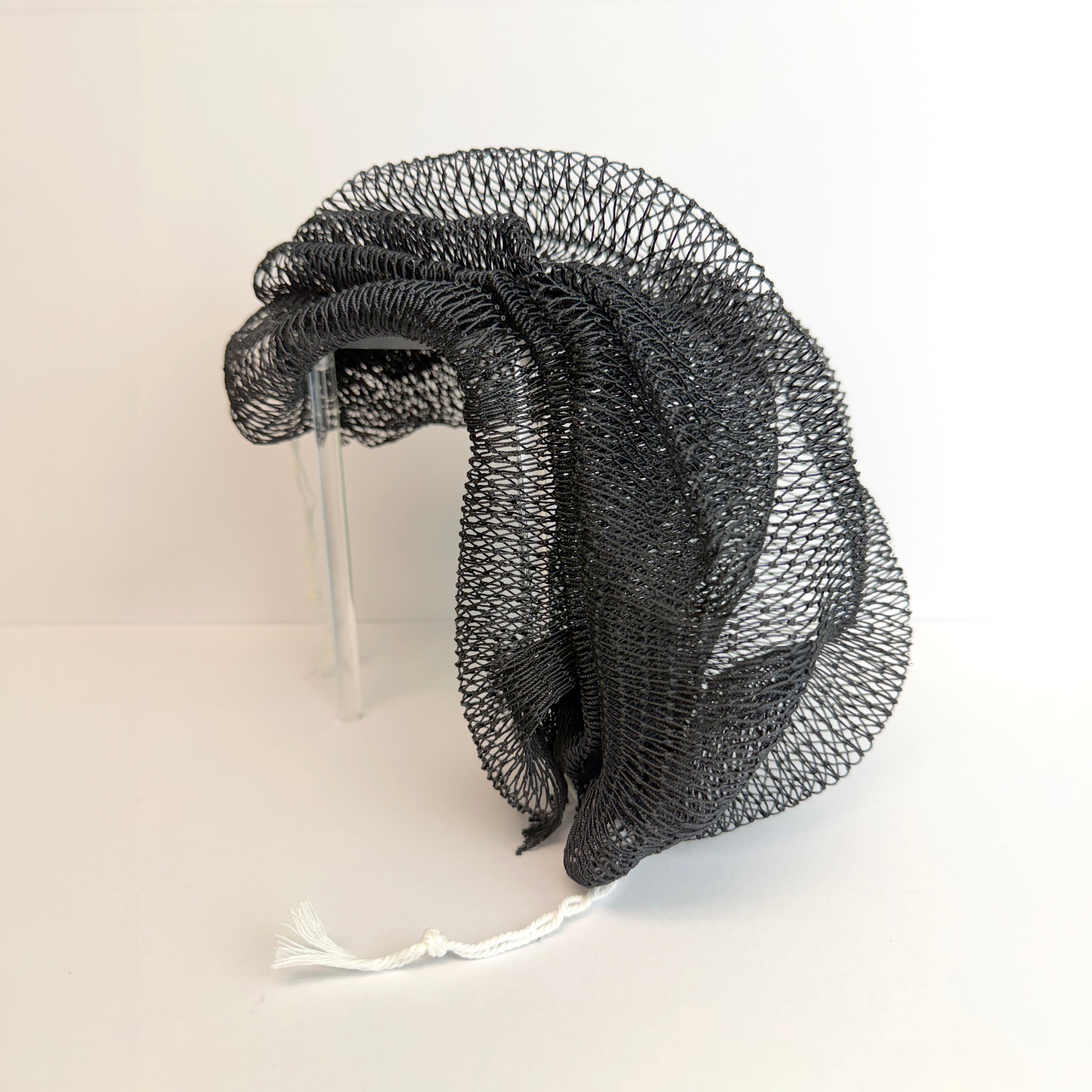 Black net sponge draped over a stand 