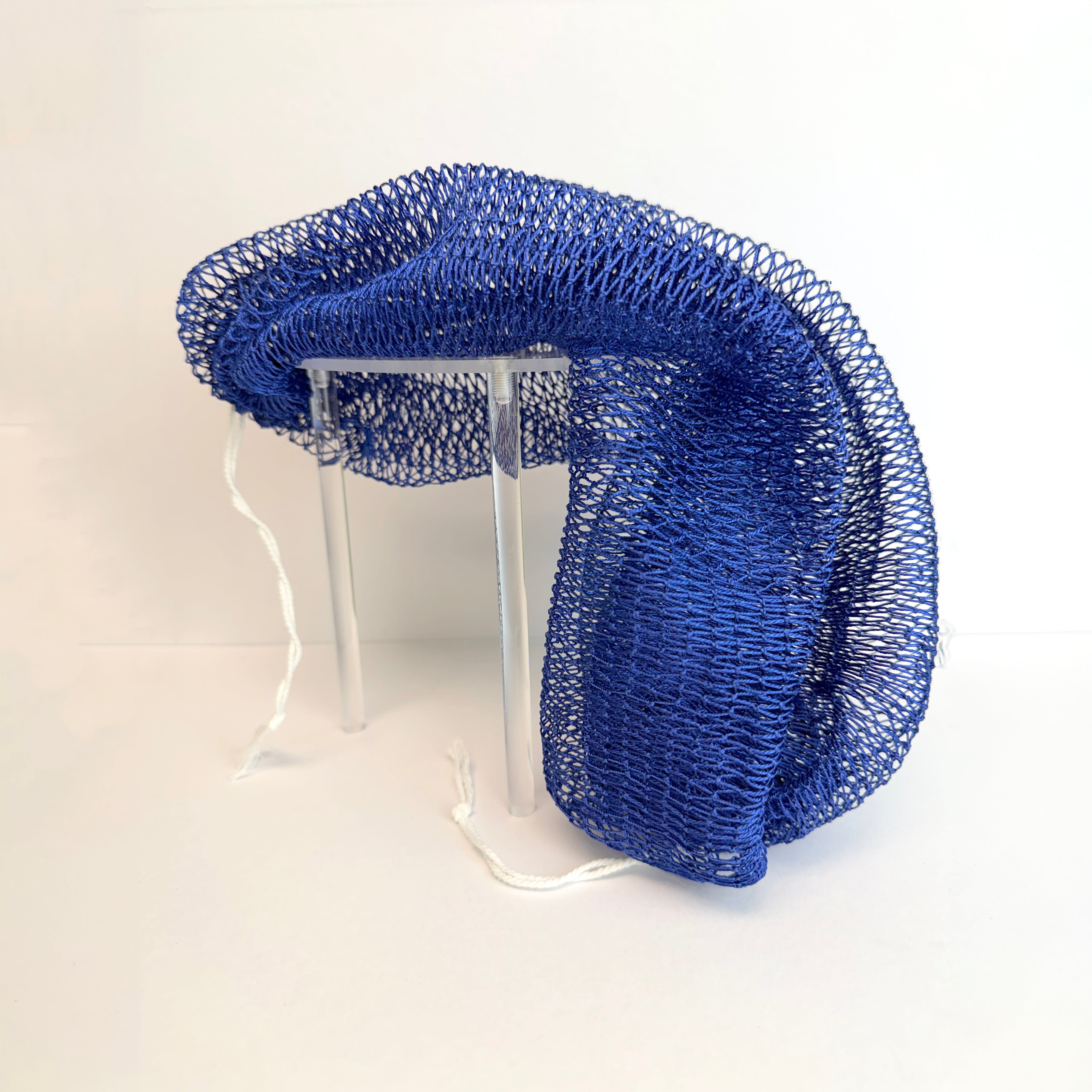 Blue net sponge draped over a stand 
