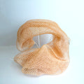 Blush orange net sponge draped over a stand 