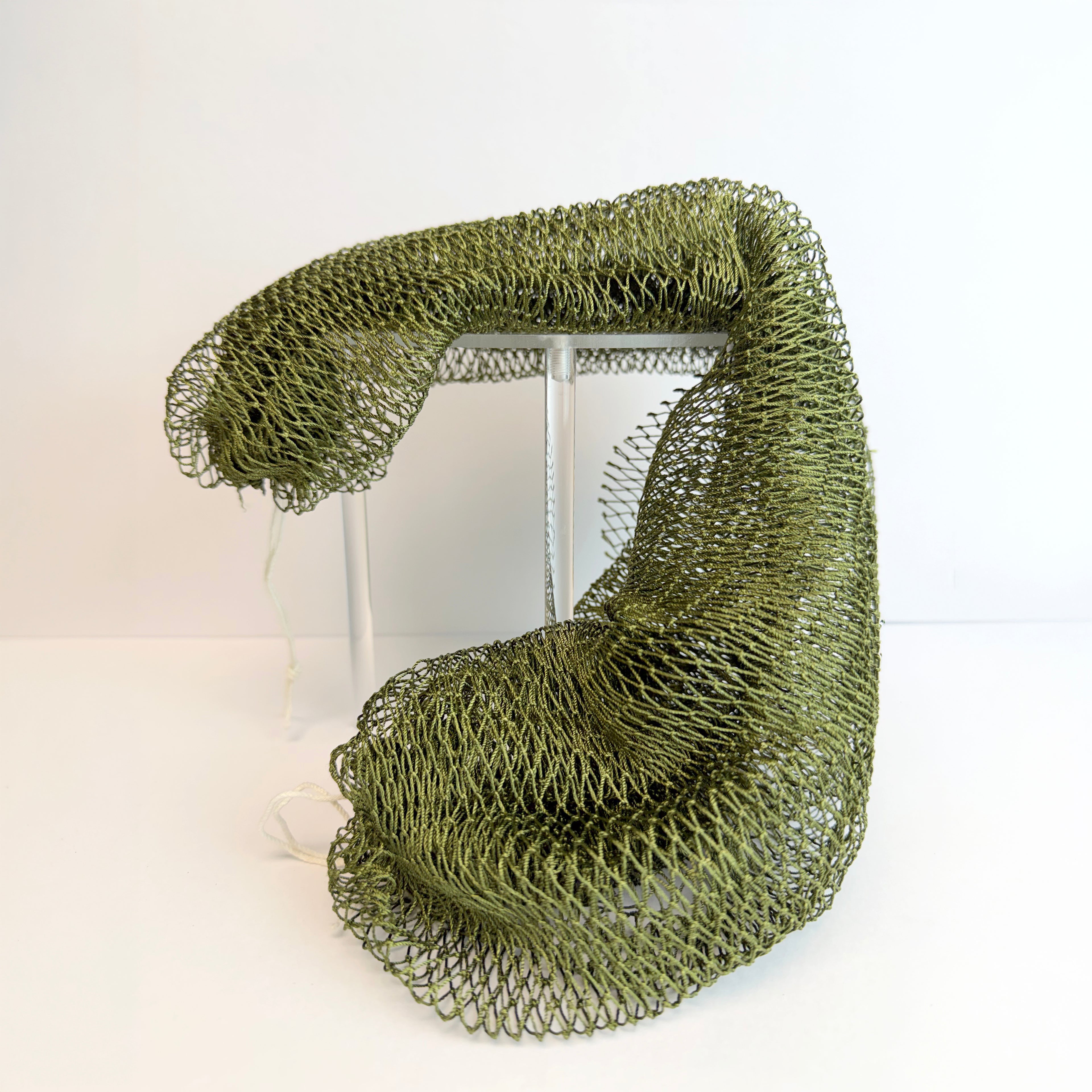 Green net sponge draped over a stand 
