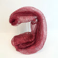 Wine red net sponge draped over a stand 