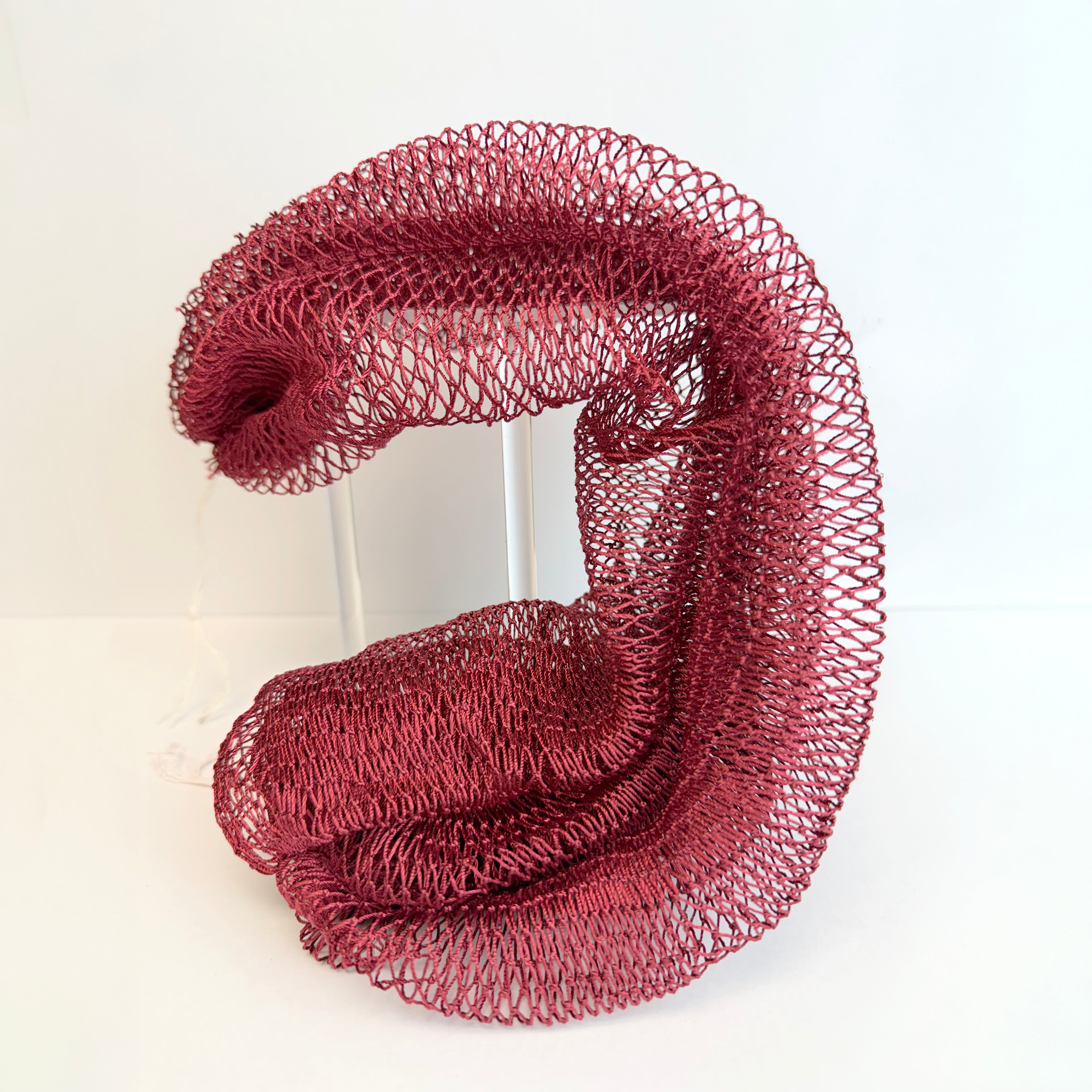 Wine red net sponge draped over a stand 